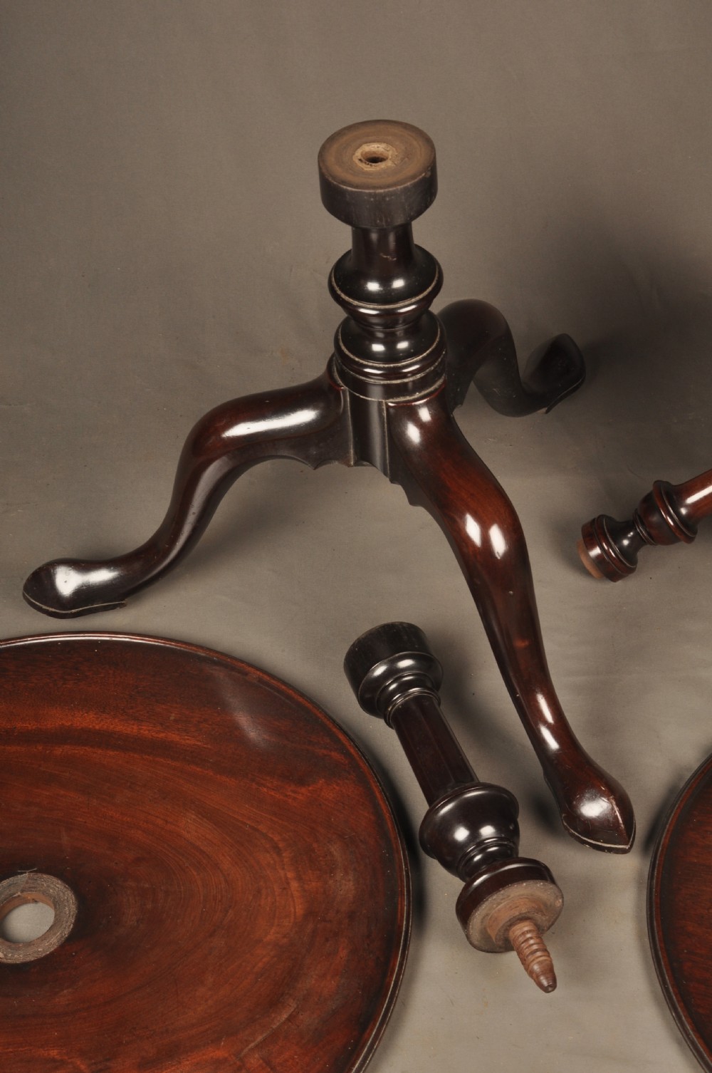 An 18th-century mahogany three-tiered dumb waiter featuring graduated dished trays, a turned central column, and tripod cabriole legs. View IX