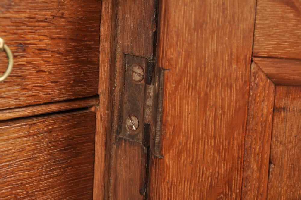 A mid-18th-century oak spice cupboard featuring a single fielded panel door with a brass keyhole escutcheon and a moulded base. View VII