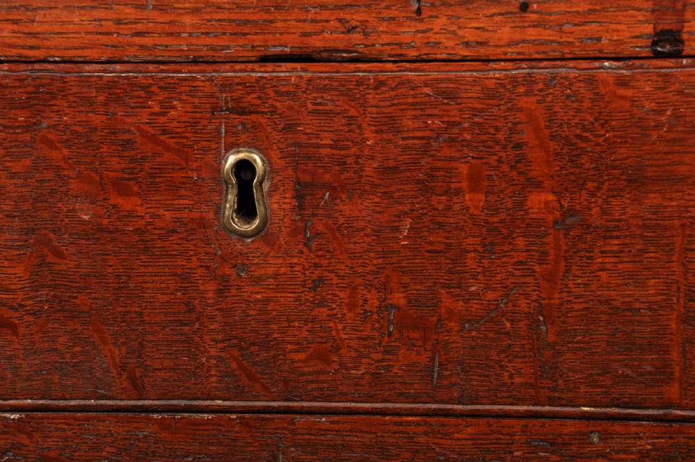 A mid-18th-century warm brown oak slant-front writing bureau featuring four graduated drawers with brass swan-neck handles and bracket feet. View VI