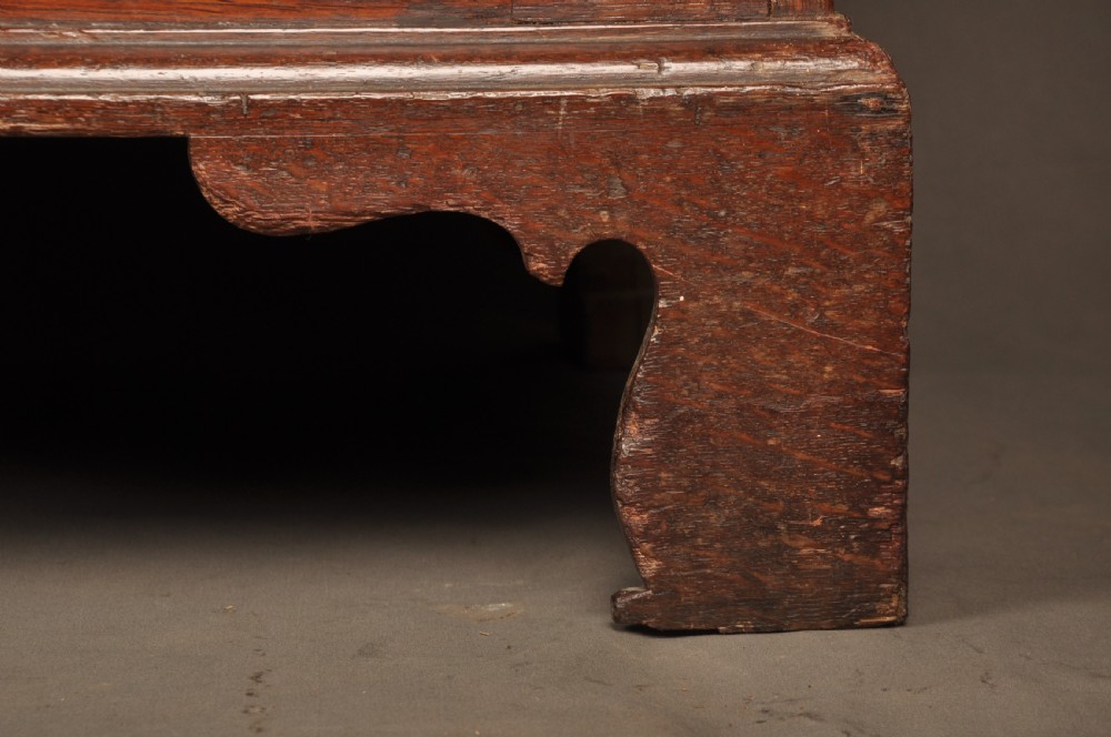 A mid-18th-century warm brown oak slant-front writing bureau featuring four graduated drawers with brass swan-neck handles and bracket feet. View XII
