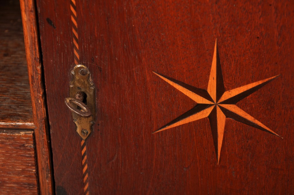 A mid-18th-century warm brown oak slant-front writing bureau featuring four graduated drawers with brass swan-neck handles and bracket feet. View XVI