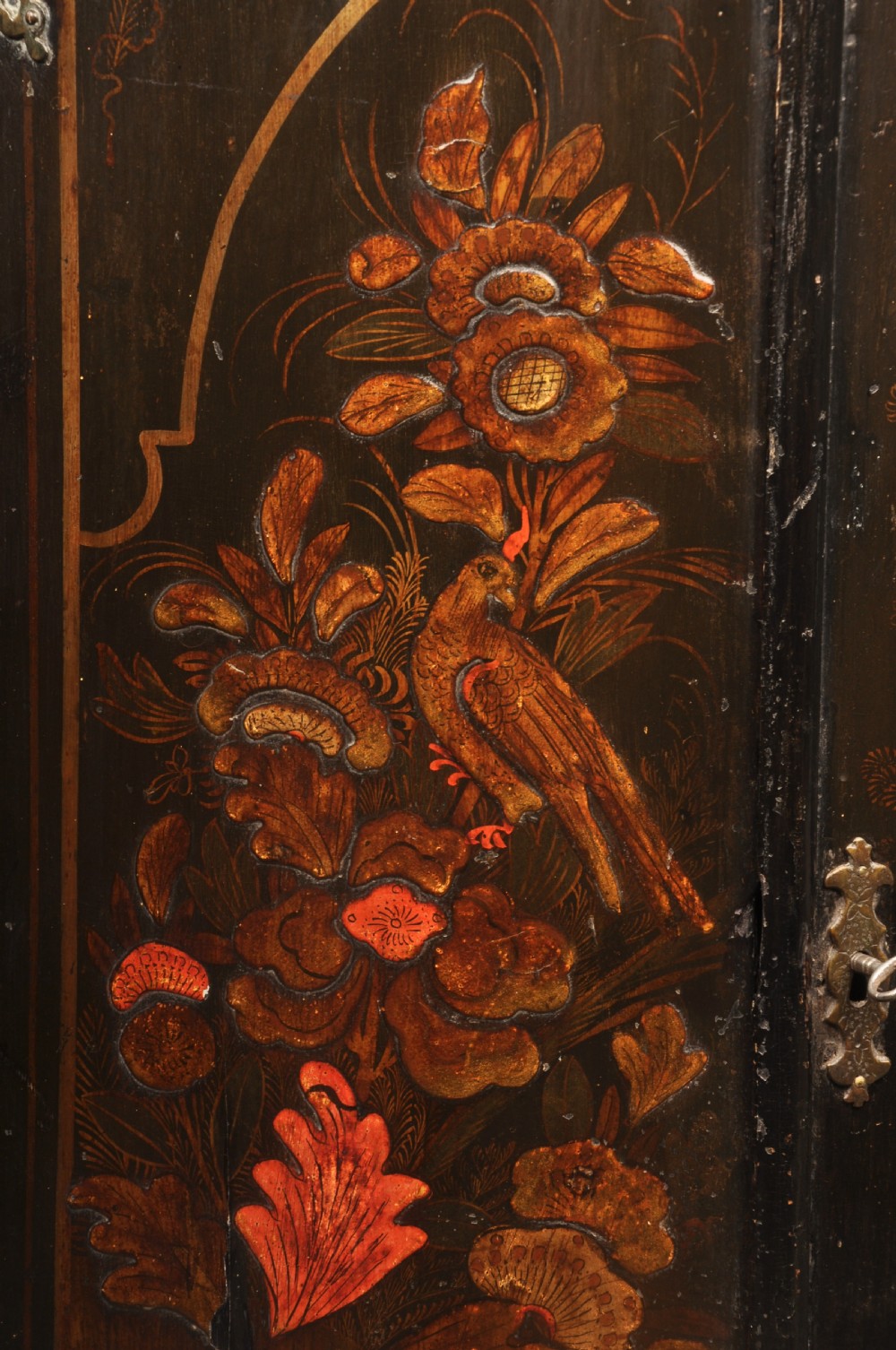 An early 18th-century black japanned hanging corner cupboard featuring hand-painted chinoiserie decoration depicting birds, flora, and architectural structures with brass butterfly hinges. View III