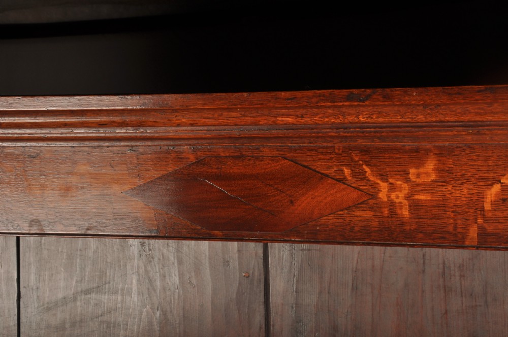 An eighteenth-century warm brown oak dresser featuring an upper three-tier open plate rack above a lower cabinet with drawers and panelled cupboard doors. View XVI