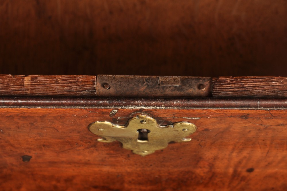 A George I burr walnut bureau bookcase with double mirrored upper doors over a slant-front slope and chest of drawers with brass handles. View VI