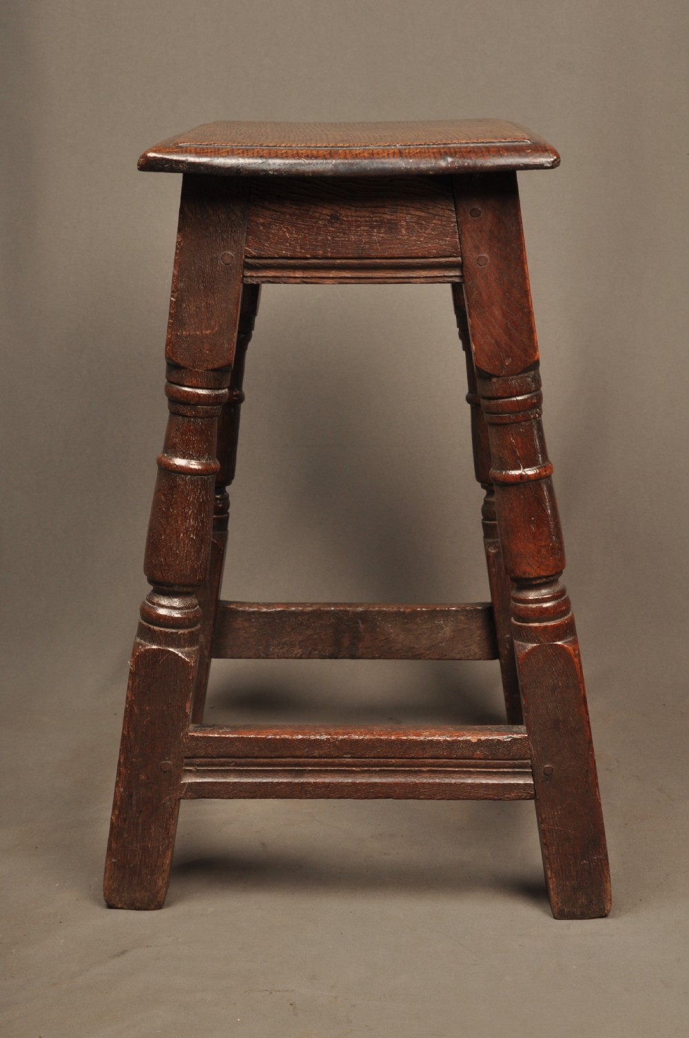 An 18th-century oak joint stool featuring baluster turned legs, plain stretchers, a rectangular moulded top, and dark brown patinated wood. View IV