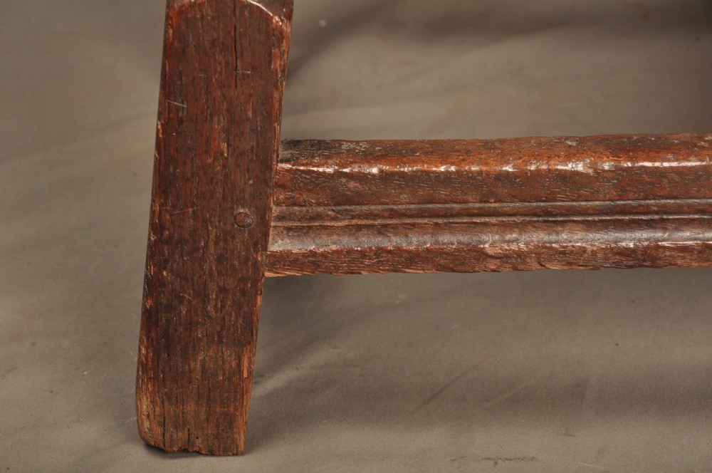 An 18th-century oak joint stool featuring baluster turned legs, plain stretchers, a rectangular moulded top, and dark brown patinated wood. View VIII