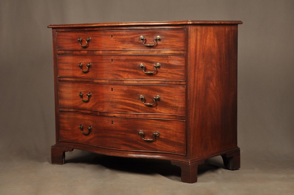 An 18th-century Georgian mahogany serpentine chest of drawers featuring four graduated drawers, brass swan-neck handles, and bracket feet.