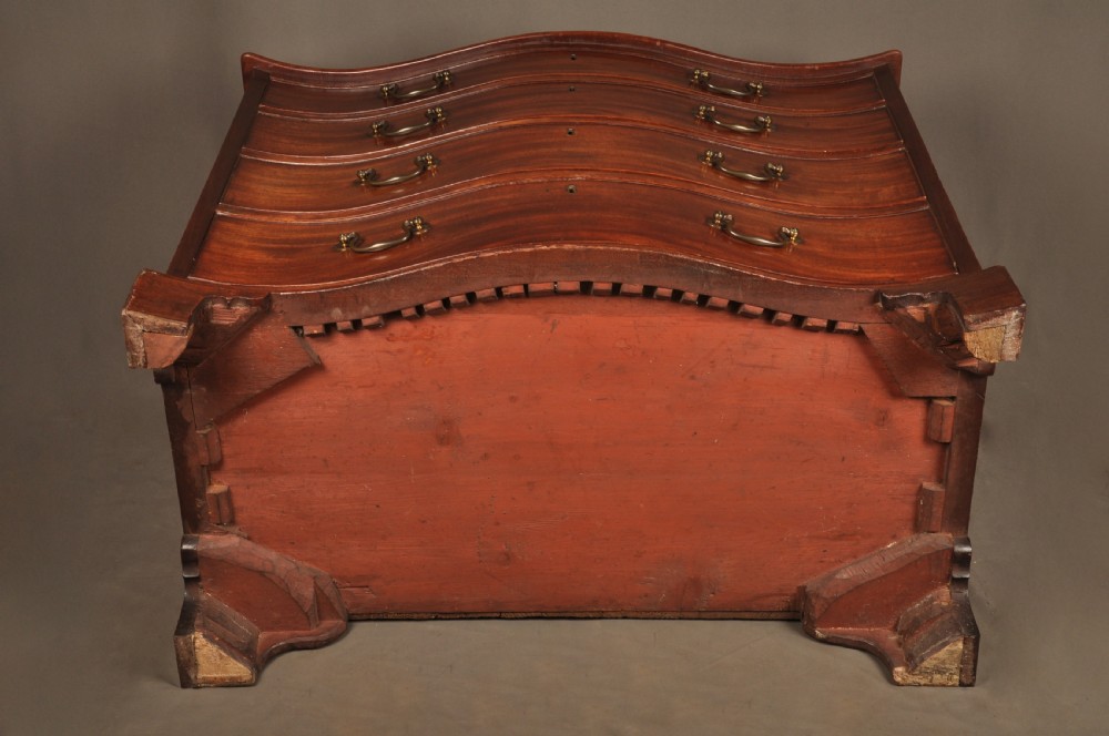 An 18th-century Georgian mahogany serpentine chest of drawers featuring four graduated drawers, brass swan-neck handles, and bracket feet. View XIII