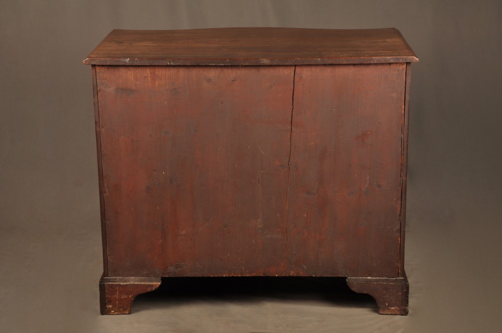 An 18th-century Georgian mahogany serpentine chest of drawers featuring four graduated drawers, brass swan-neck handles, and bracket feet. View XV