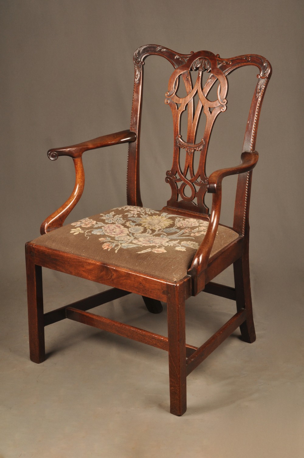 An 18th-century Georgian Chippendale mahogany armchair featuring a carved pierced splat back, shaped arms, and a floral needlepoint drop-in seat. View III