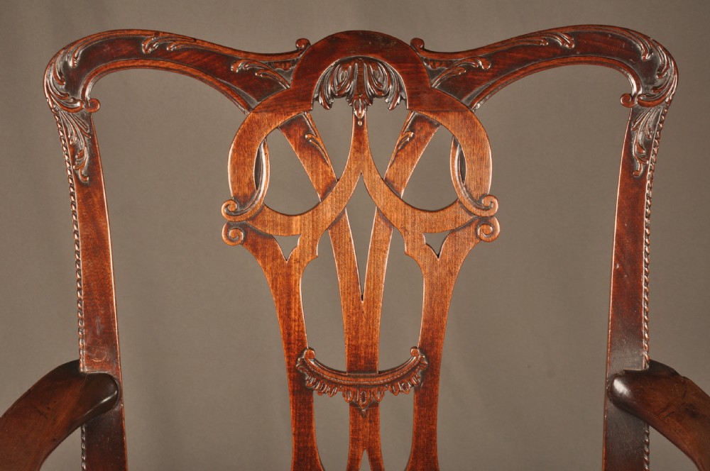 An 18th-century Georgian Chippendale mahogany armchair featuring a carved pierced splat back, shaped arms, and a floral needlepoint drop-in seat. View VI