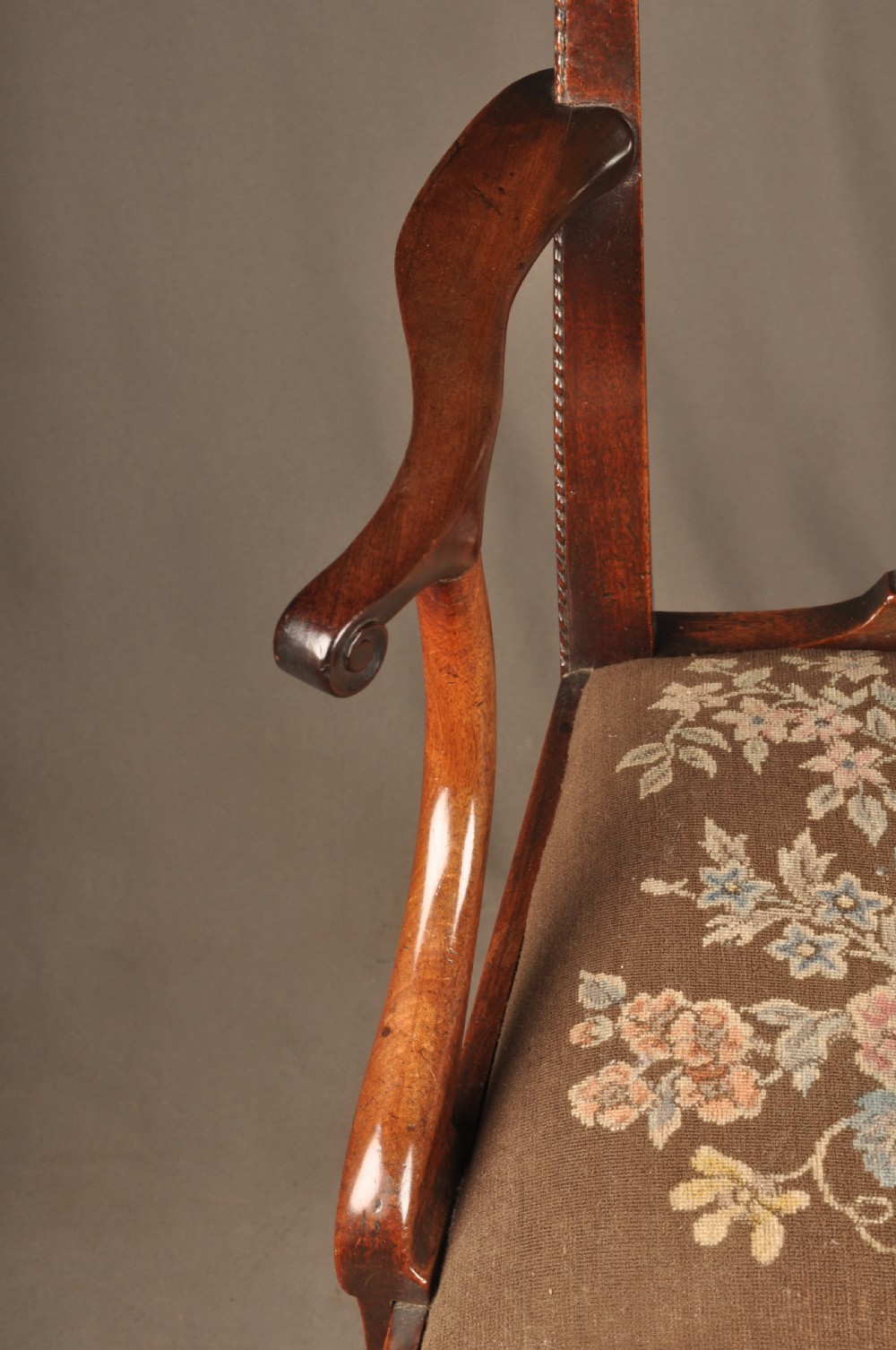 An 18th-century Georgian Chippendale mahogany armchair featuring a carved pierced splat back, shaped arms, and a floral needlepoint drop-in seat. View VIII