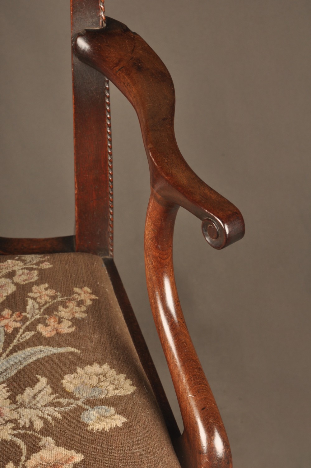 An 18th-century Georgian Chippendale mahogany armchair featuring a carved pierced splat back, shaped arms, and a floral needlepoint drop-in seat. View IX