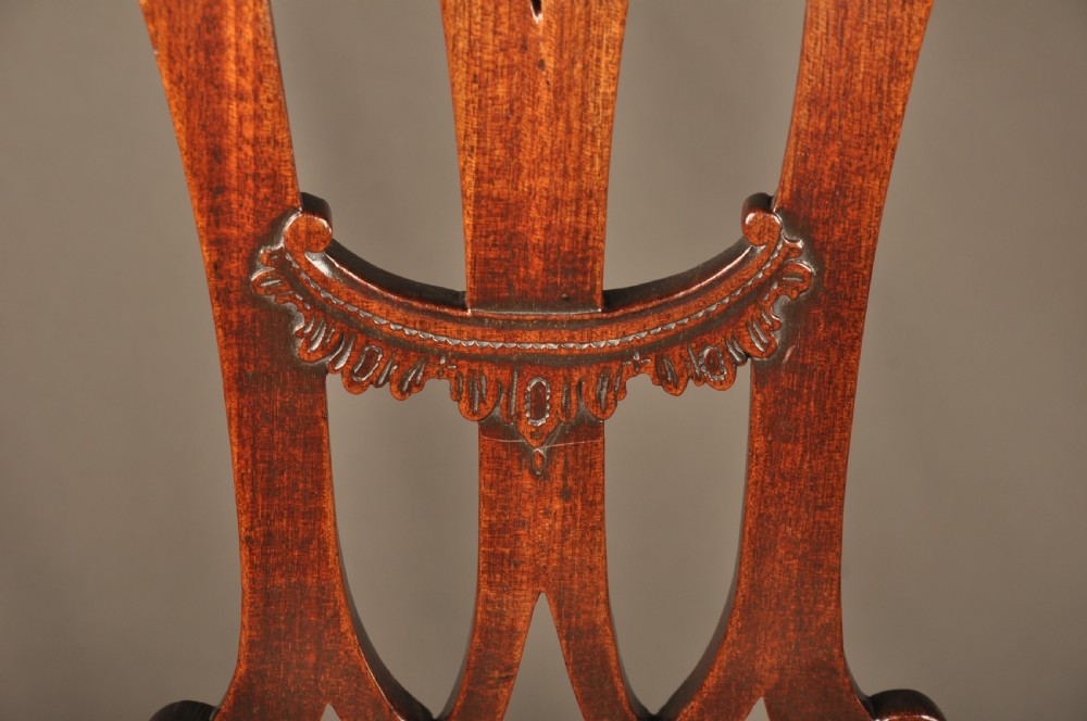 An 18th-century Georgian Chippendale mahogany armchair featuring a carved pierced splat back, shaped arms, and a floral needlepoint drop-in seat. View XIII