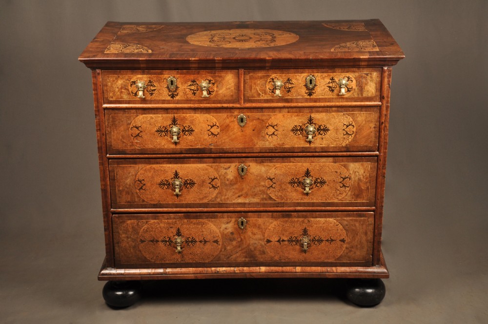 A late 17th-century walnut chest of drawers featuring arabesque marquetry inlays, tear-drop brass handles, and ebonised bun feet. View II