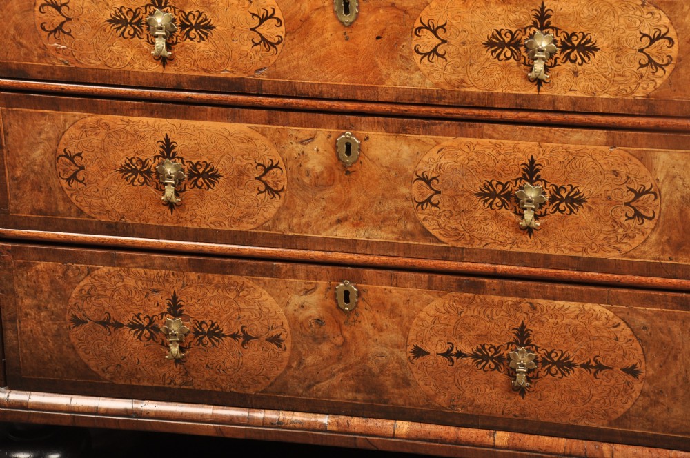 A late 17th-century walnut chest of drawers featuring arabesque marquetry inlays, tear-drop brass handles, and ebonised bun feet. View III