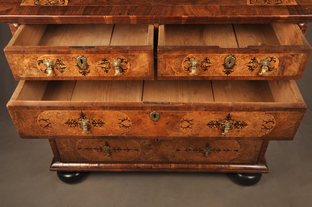 A late 17th-century walnut chest of drawers featuring arabesque marquetry inlays, tear-drop brass handles, and ebonised bun feet. View VIII