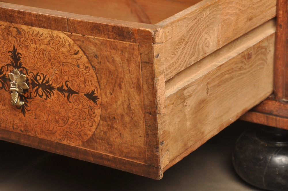 A late 17th-century walnut chest of drawers featuring arabesque marquetry inlays, tear-drop brass handles, and ebonised bun feet. View IX