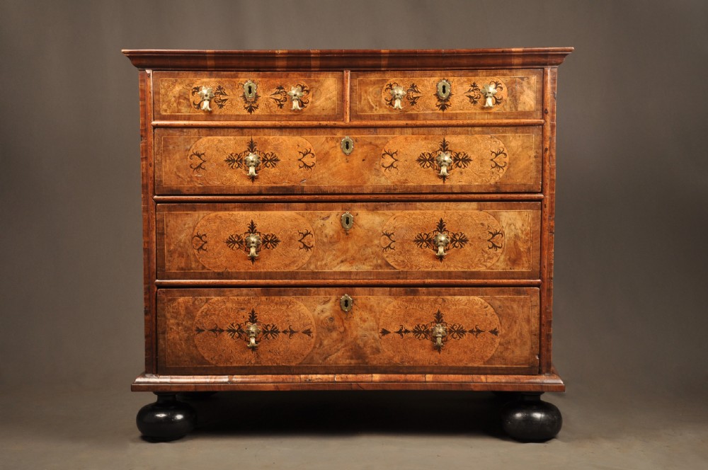 A late 17th-century walnut chest of drawers featuring arabesque marquetry inlays, tear-drop brass handles, and ebonised bun feet. View XII