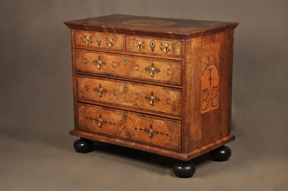A late 17th-century walnut chest of drawers featuring arabesque marquetry inlays, tear-drop brass handles, and ebonised bun feet. View XIII