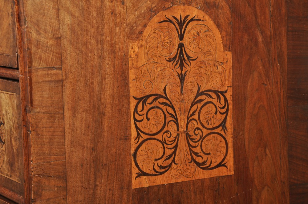 A late 17th-century walnut chest of drawers featuring arabesque marquetry inlays, tear-drop brass handles, and ebonised bun feet. View XIV