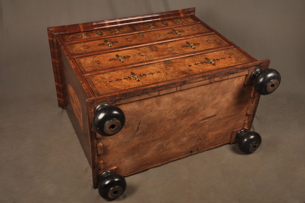 A late 17th-century walnut chest of drawers featuring arabesque marquetry inlays, tear-drop brass handles, and ebonised bun feet. View XVI