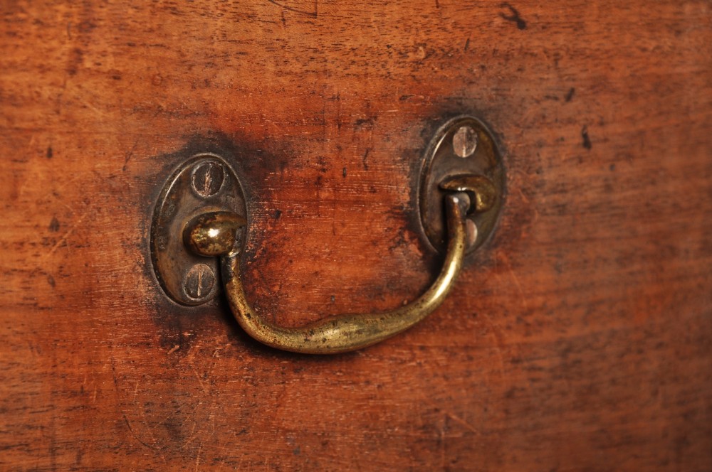 A Sheraton style mahogany cellarette featuring a hinged sarcophagus top, brass side handles, and square tapered legs on brass castors. View VIII