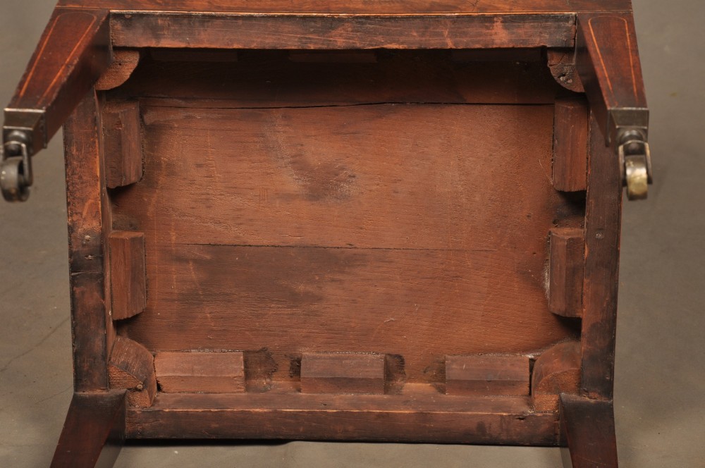 A Sheraton style mahogany cellarette featuring a hinged sarcophagus top, brass side handles, and square tapered legs on brass castors. View X