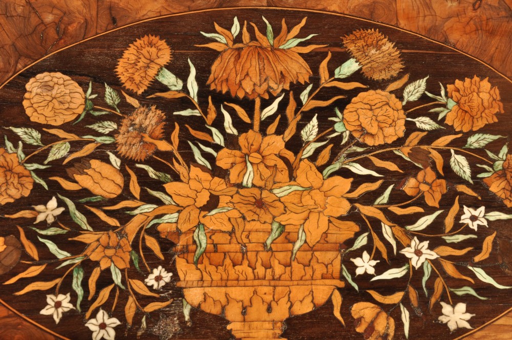 An antique brown walnut centre table featuring detailed floral marquetry inlays across the tabletop, single drawer front, and stretcher base, supported by bobbin-turned legs. View IX