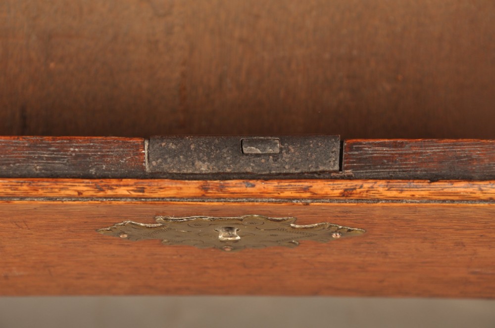 An early 18th-century oak bureau featuring a slant-front writing flap above two short and two long drawers with brass hardware. View IV