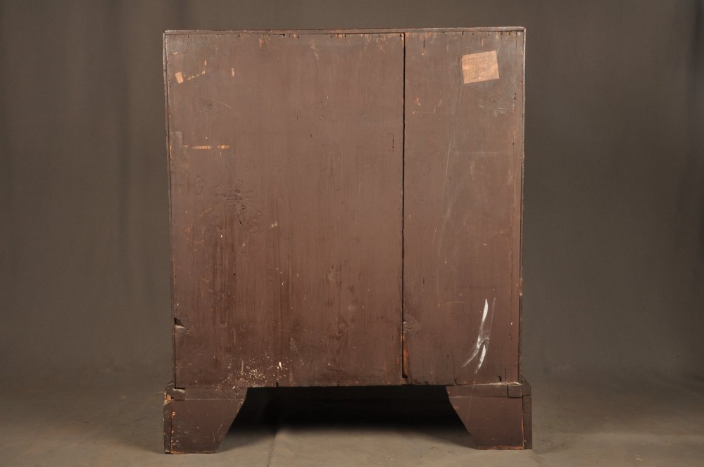An early 18th-century oak bureau featuring a slant-front writing flap above two short and two long drawers with brass hardware. View XV