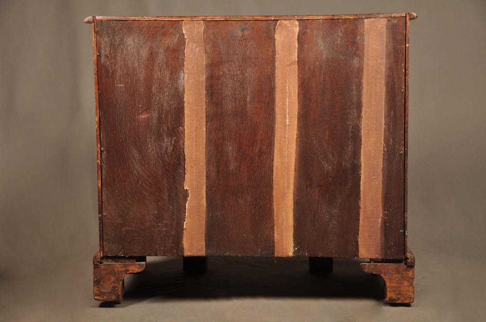 A Queen Anne walnut kneehole desk featuring figured wood veneers, seven drawers with brass handles, a central recessed cupboard, and bracket feet. View XIV