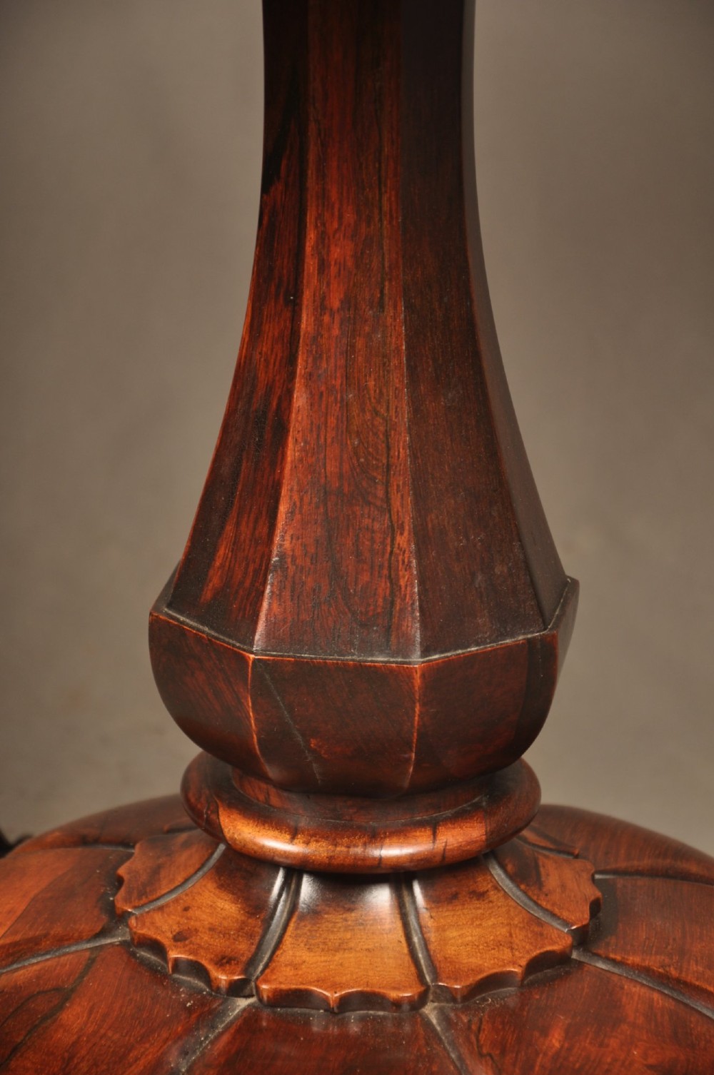A Regency period rosewood fold-over card table featuring a carved apron, a central pedestal column, and a fluted quadripartite base on brass castors. View III