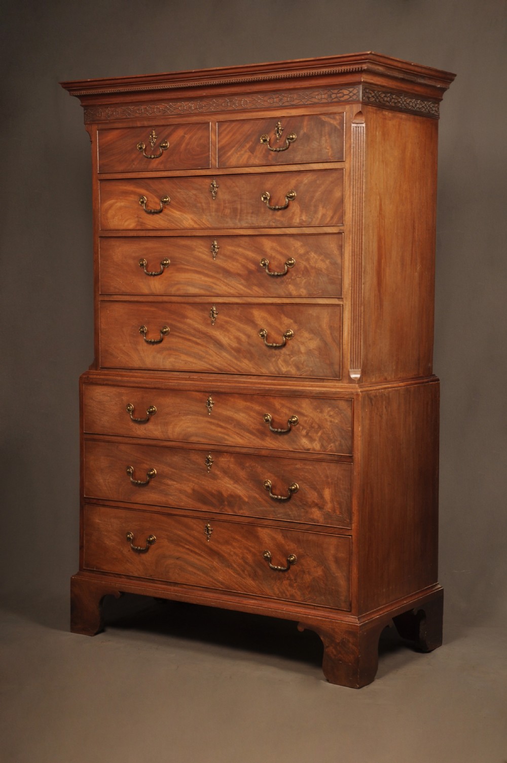 An 18th-century Georgian mahogany tallboy chest-on-chest with flame mahogany drawer fronts, brass swan-neck handles, fluted quarter columns, and bracket feet. View II