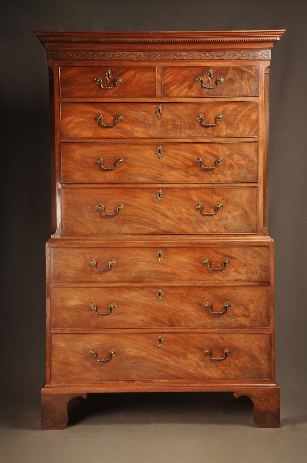 An 18th-century Georgian mahogany tallboy chest-on-chest with flame mahogany drawer fronts, brass swan-neck handles, fluted quarter columns, and bracket feet. View III