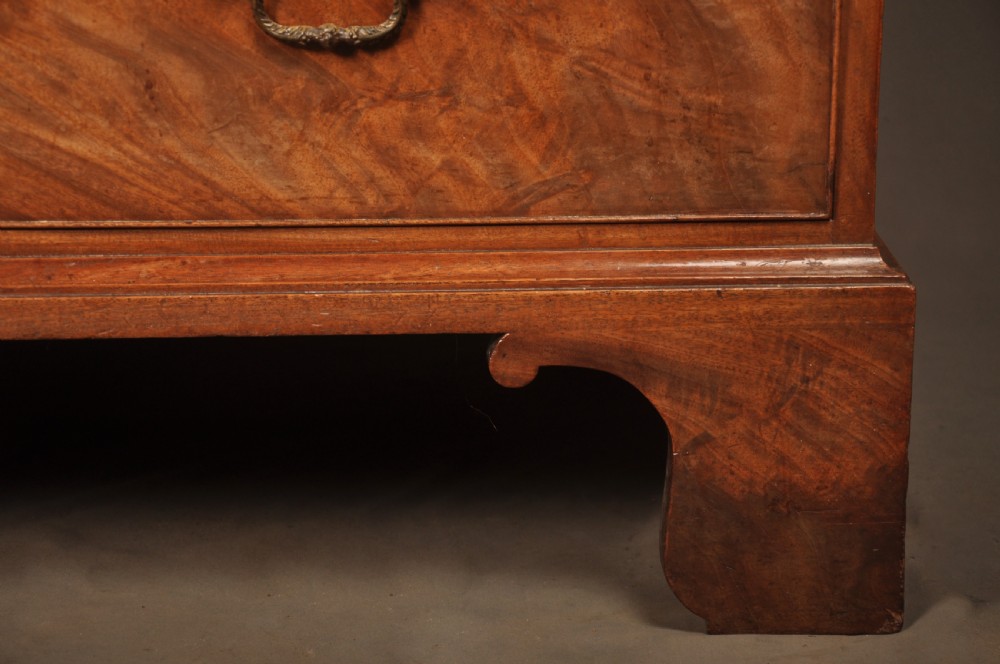An 18th-century Georgian mahogany tallboy chest-on-chest with flame mahogany drawer fronts, brass swan-neck handles, fluted quarter columns, and bracket feet. View IV