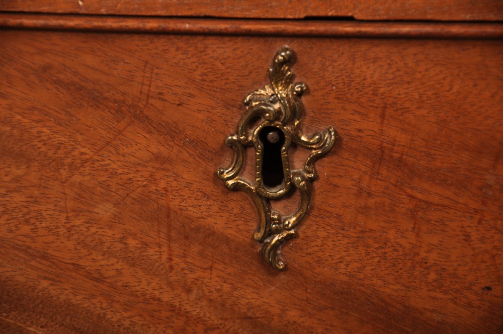 An 18th-century Georgian mahogany tallboy chest-on-chest with flame mahogany drawer fronts, brass swan-neck handles, fluted quarter columns, and bracket feet. View VII