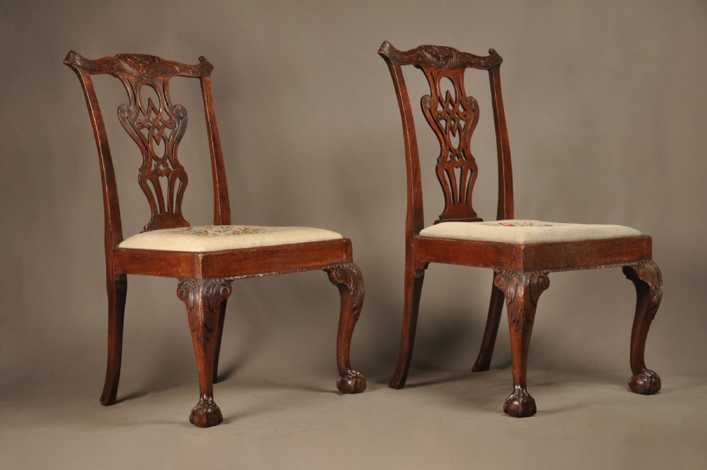 A pair of 18th-century George II mahogany side chairs featuring pierced carved splats, cabriole legs with claw and ball feet, and floral needlepoint drop-in seats. View II