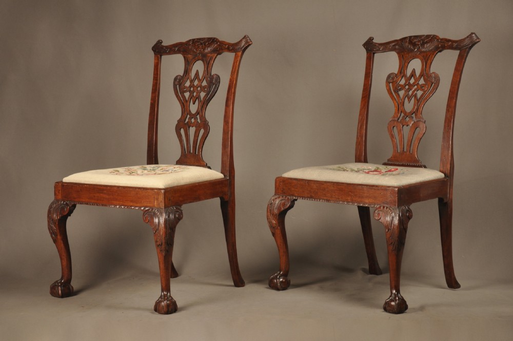A pair of 18th-century George II mahogany side chairs featuring pierced carved splats, cabriole legs with claw and ball feet, and floral needlepoint drop-in seats. View III