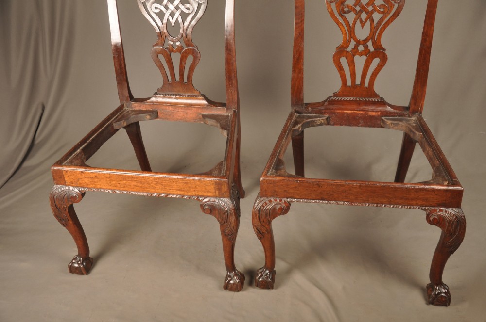 A pair of 18th-century George II mahogany side chairs featuring pierced carved splats, cabriole legs with claw and ball feet, and floral needlepoint drop-in seats. View VIII