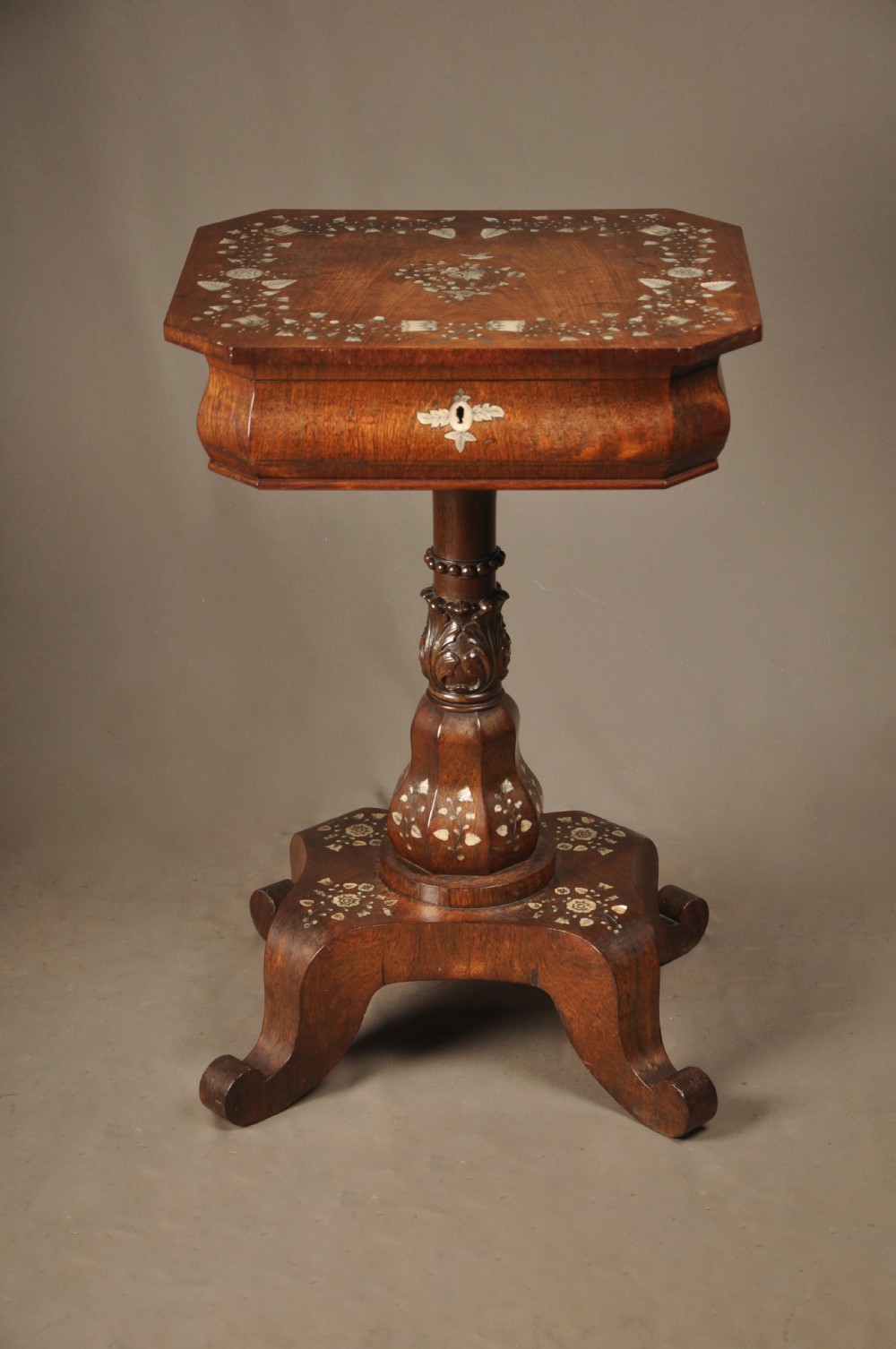 An antique octagonal mahogany work table with mother-of-pearl floral inlay, a central carved pedestal, and a quadruped base. View XVII