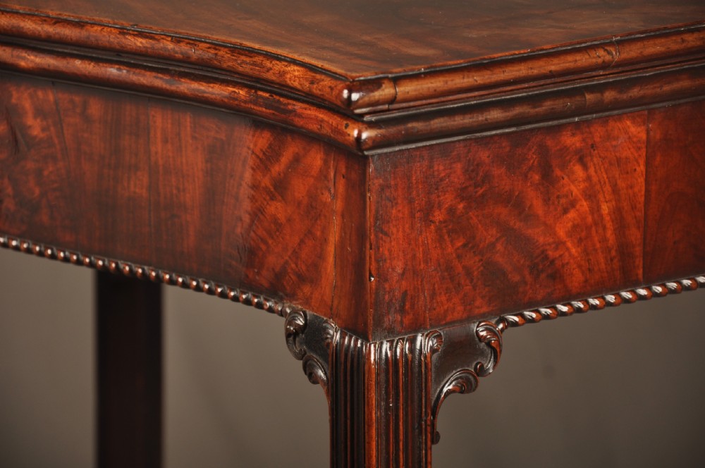 An 18th-century Georgian mahogany card table with a folded serpentine top and fluted legs. View IV
