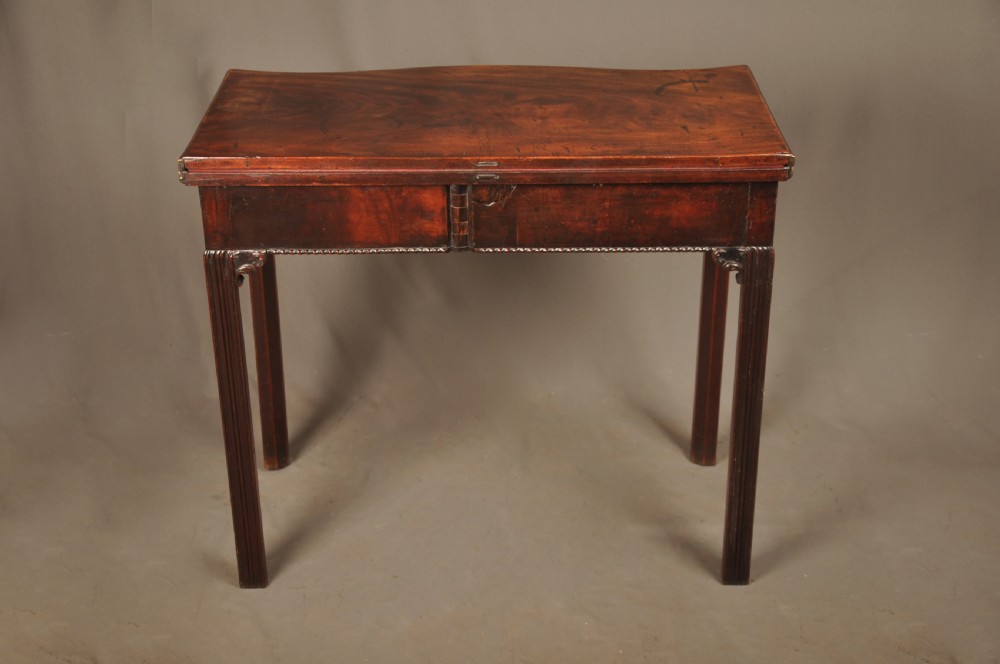 An 18th-century Georgian mahogany card table with a folded serpentine top and fluted legs. View VI