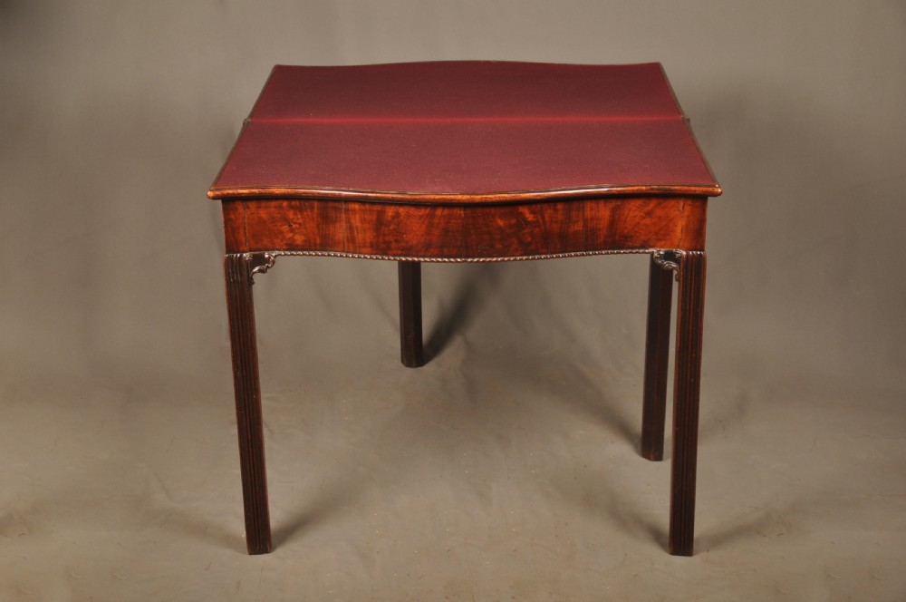 An 18th-century Georgian mahogany card table with a folded serpentine top and fluted legs. View VII