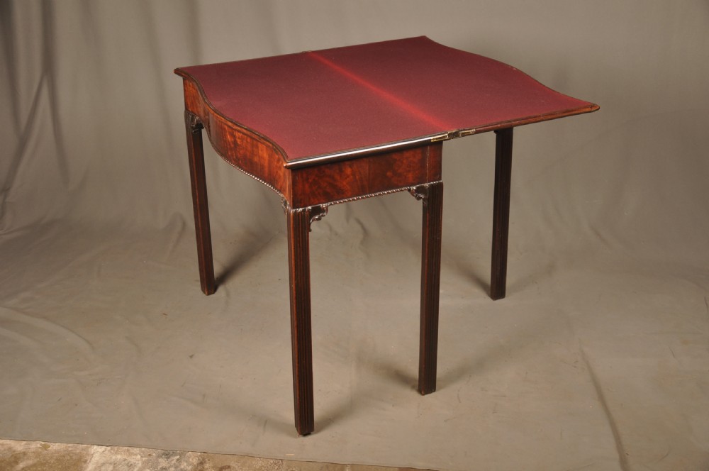 An 18th-century Georgian mahogany card table with a folded serpentine top and fluted legs. View VIII
