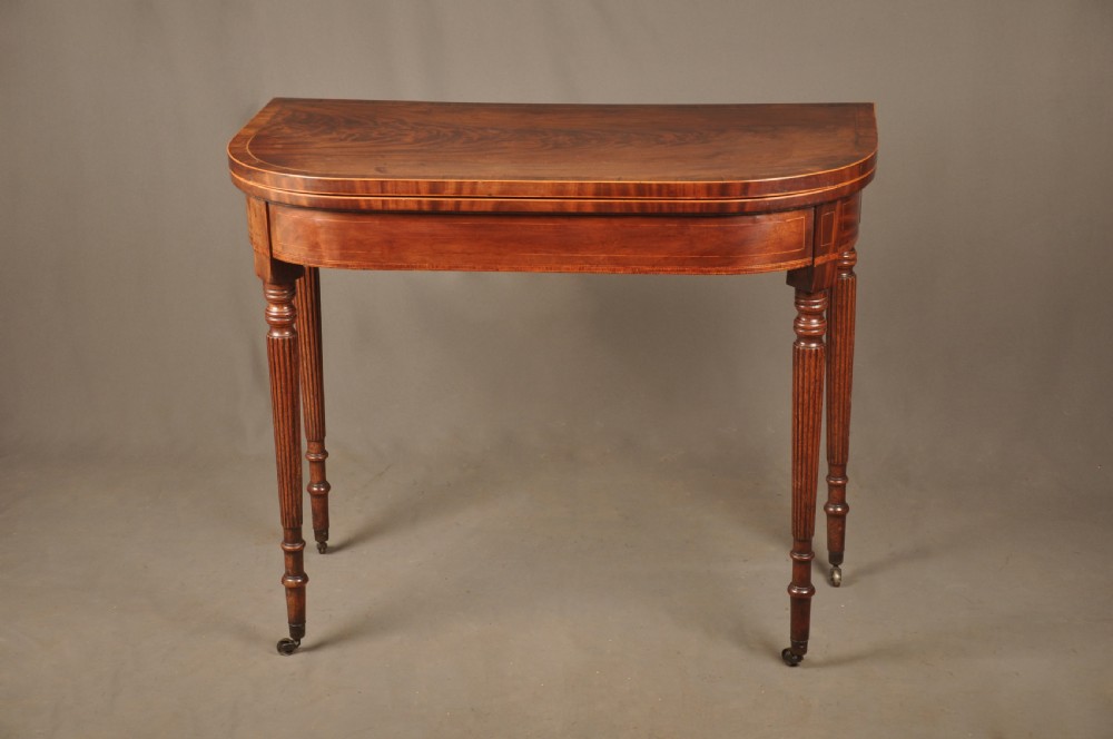 A late eighteenth-century mahogany fold-over card table featuring satinwood inlay, a reeded apron, and fluted legs on brass castors. View III