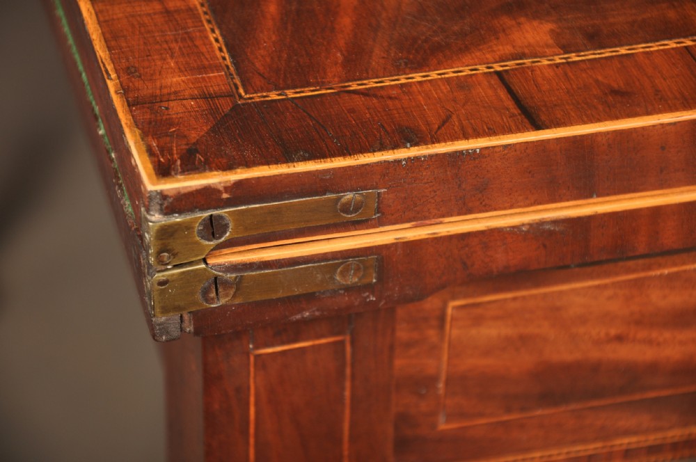 A late eighteenth-century mahogany fold-over card table featuring satinwood inlay, a reeded apron, and fluted legs on brass castors. View IX