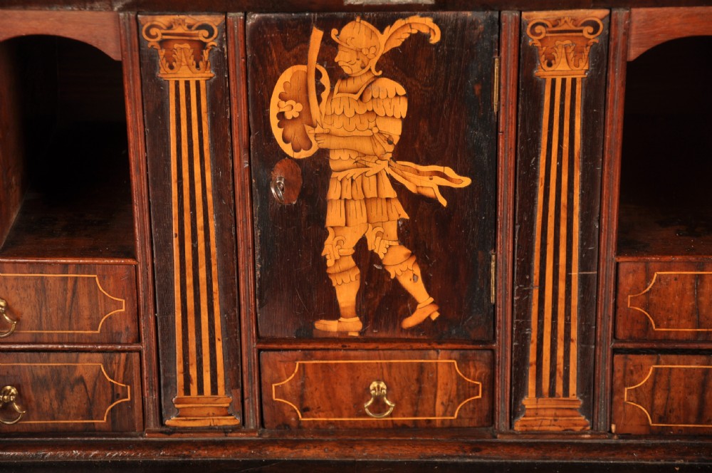 An early 18th-century Irish walnut slant-front bureau featuring engraved brass drop handles, keyhole escutcheons, and bracket feet. View IV