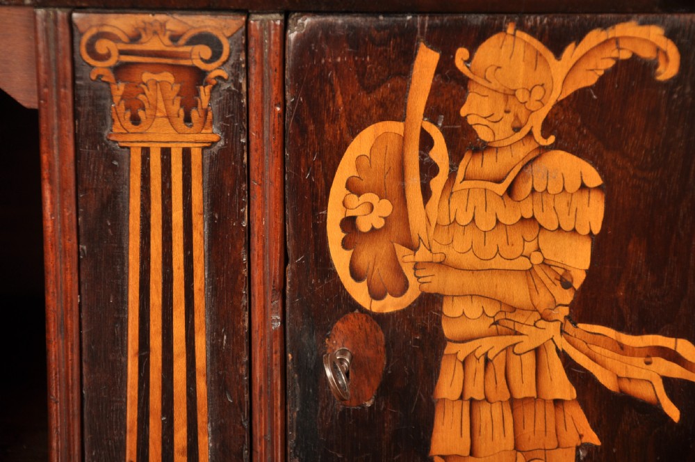 An early 18th-century Irish walnut slant-front bureau featuring engraved brass drop handles, keyhole escutcheons, and bracket feet. View VIII