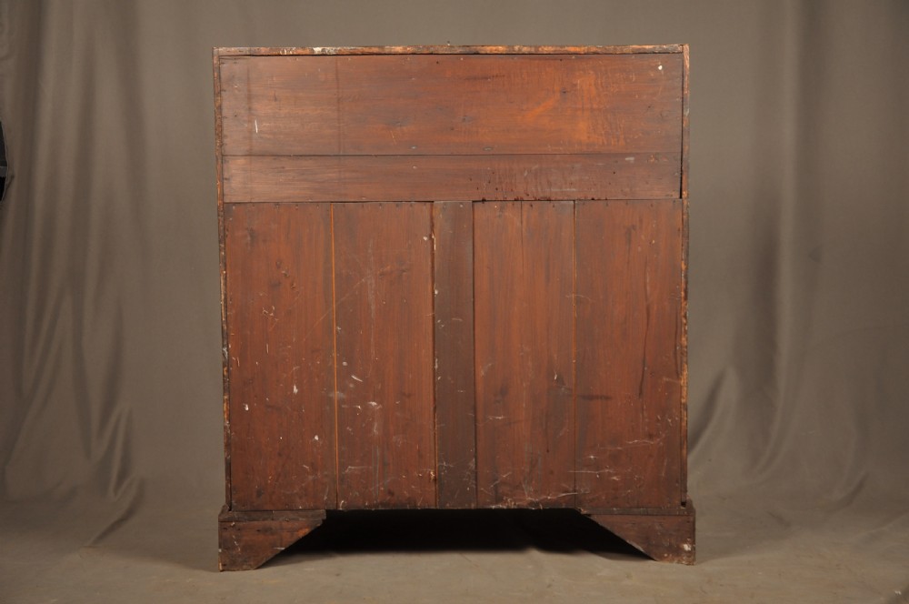 An early 18th-century Irish walnut slant-front bureau featuring engraved brass drop handles, keyhole escutcheons, and bracket feet. View XVI